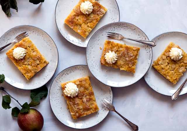 5 Stück leckerer, saftiger Apfelkuchen mit Mandelkruste aus dem Holzbackofen auf Tellern