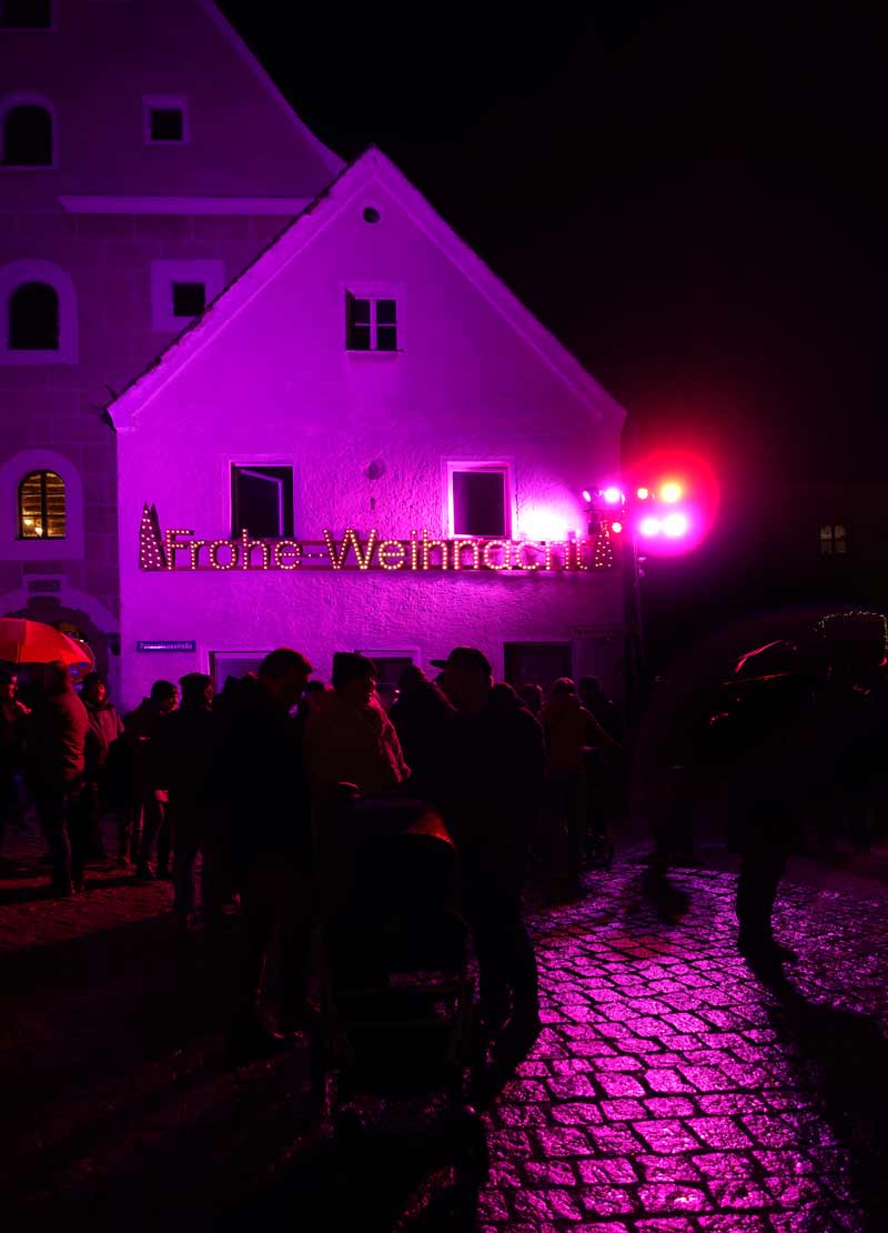 Rosa erleuchtetes Fachwerkhaus mit riesiger Leuchtschrift „Frohe Weihnacht“ – Beratzhausen Adventszauber 2025