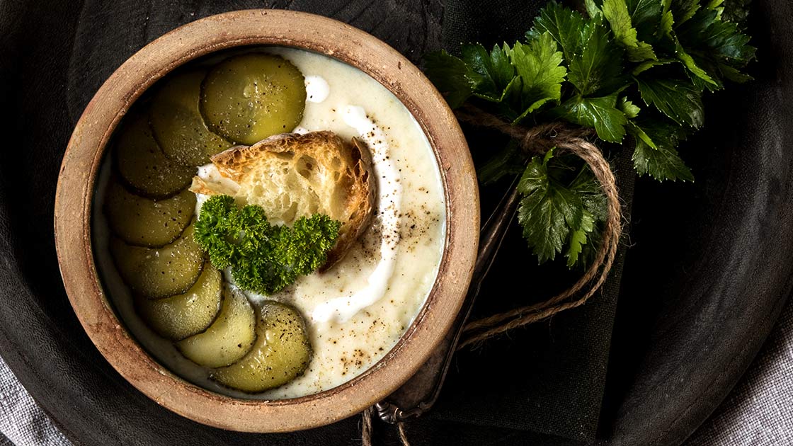 Eine frisch gekochte, cremige Sellerie-Suppe süß-sauer verfeinert mit Gewürzgurken und frischer Petersilie