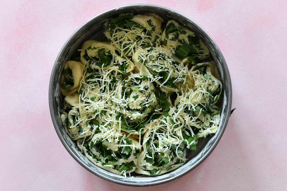 Bärlauchschnecken in Backform mit Käse bestreut