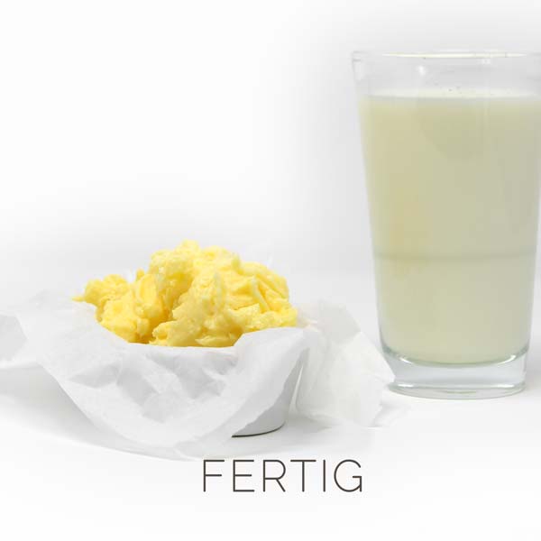 Selbstgemachte Butter nach Trennung von der Buttermilch in ein Glas gießen