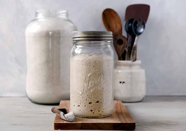 Frischer Sauerteig in einem Glas mit Blasenbildung