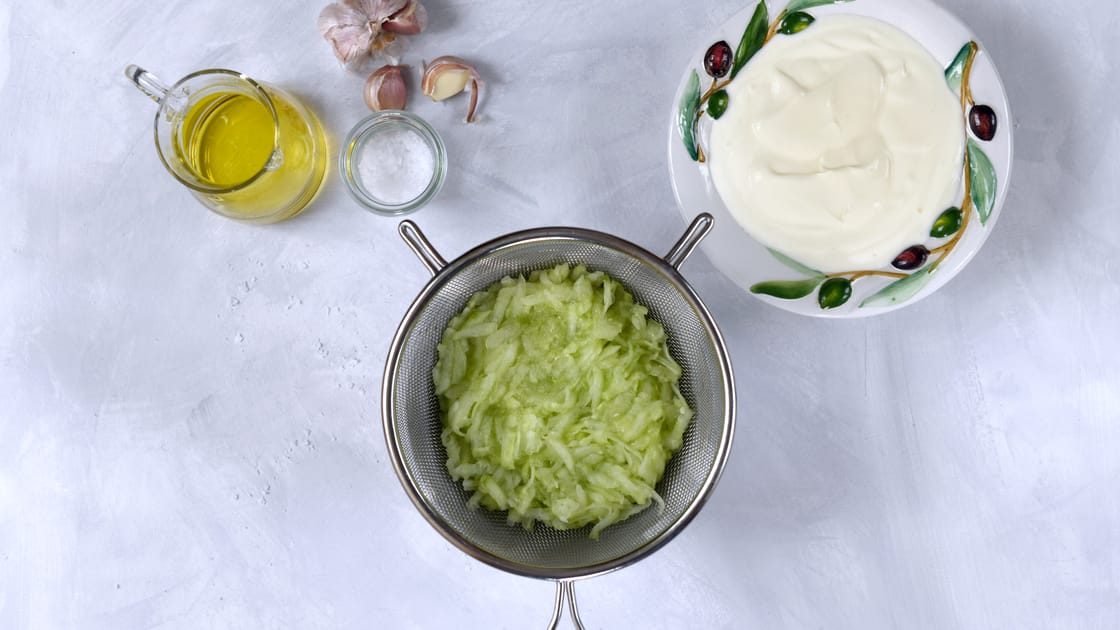 Zutaten für Zaziki: griechischer Joghurt, Salatgurke, Knoblauch und Olivenöl