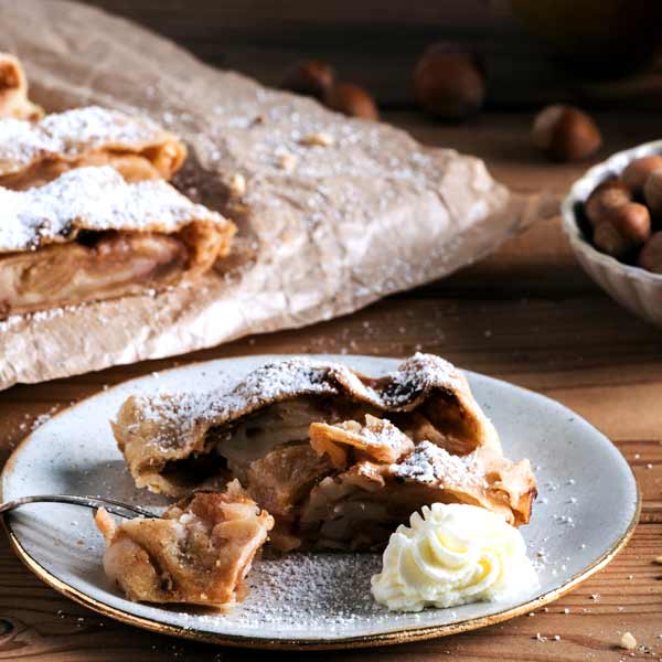 Ein Stück frischgebackener Apfelstrudel mit Sahne